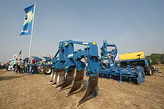 Figuur II: voorzetwoeler met zes woelpoten. De tanden zijn zijdelings gekromd en beveiligd met een breekboutbeveiliging.