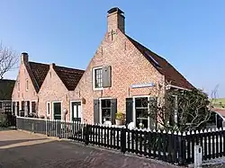 Twee huisjes (Reddingsboatreed 2) zonder verdieping onder met rode pannen gedekt zadeldak tussen puntgevels