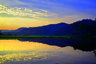 De weerspiegeling van de heuvel in het onbeplante rijstveld. Het Limpung gebied.
