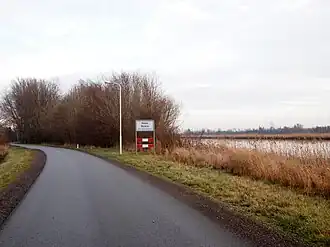 Plaatsnaambord aan de westkant van Rohel met rechts het Prinses Margrietkanaal