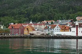 Zicht vanaf het water op de voormalige vispakhuizen, het grote rode gebouw links is het museum.