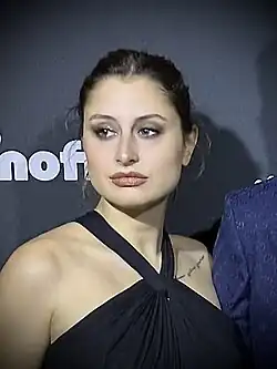 Saar tijdens première van Zwijgrecht in Pathé Tuschinski. Zwarte jurk, donkere achtergrond. Close-up foto.