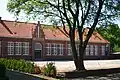 Jongensschool, eenlaags langgerekt bakstenen gebouw op rechthoekige plattegrond onder schilddak