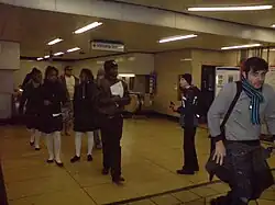 De doorgang en roltrap naar de metro in de stationshal