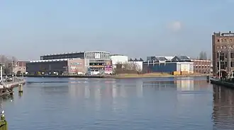 Gezicht op de voormalige Figee-fabriek aan het Spaarne, tegenwoordig kantoorunits. Rechts valt de oude Drostefabriek te zien.