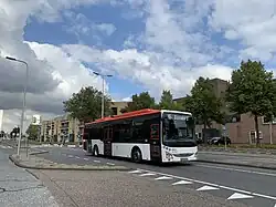 Stadsbus met daarachter de Gildenwijk