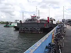Fietsenstalling op een aangemeerde veerpont bij Amsterdam CS (2021). Dit is de oude Rijkspont nr. 5, die vroeger over het Noordzeekanaal voer.