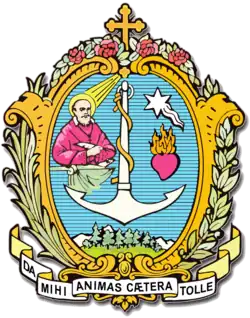 Blazoen van de Salesianen, met daarin de beeltenis van de heilige Franciscus van Sales, het anker, de stralende ster en het brandende hart als verwijzing naar de deugden Geloof, Hoop en Liefde, het bos dat verwijst naar de familienaam van Giovanni Bosco en de laurier en de palm als symbolen voor het eeuwig leven en Christus die de dood overwon.