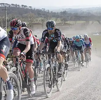 Winnaar Tadej Pogačar (links) in het peloton