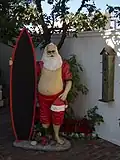 De kerstman met een surfboard in  Laguna Beach, Californië