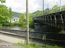 Een spoorbrug (met looprand) over de Ourthe met op de achtergrond Sy