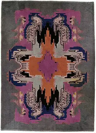 Vloerkleed met een kleurig art déco-patroon binnen een effen grijsgroene rand, 1920