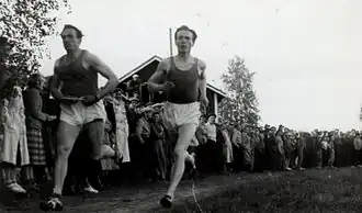 Iso-Hollo (rechts) samen met speerwerper Rautavaara in 1951 in actie in een loop om geld in te zamelen voor de OS van 1952.