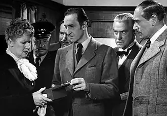 Scène uit Terror by Night met (v.l.n.r.) Mary Forbes, Billy Bevan, Alan Mowbray, Basil Rathbone, Nigel Bruce en Dennis Hoey