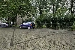 Contouren van de vroegere kloosterkerk in de weg achter de kerk