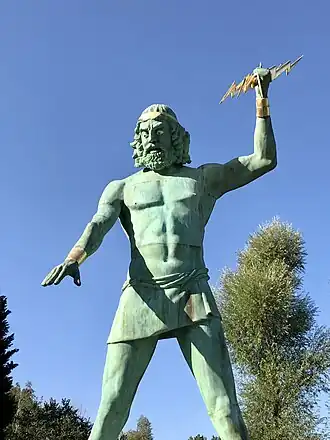 Het beeld van Zeus dat boven de ingang van de wachtrij staat