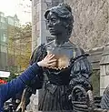 Een toerist raakt het standbeeld van Molly Malone aan