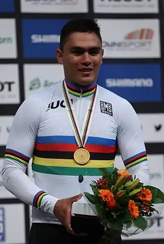 Puerta in de regenboogtrui na zijn overwinning op de keirin tijdens het WK 2018.