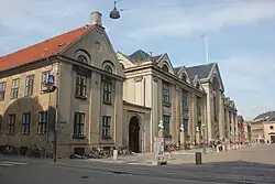 De universiteit met ervoor de bustes van alumni.