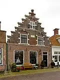 Pand met boven de puibalk een versierde trapgevel