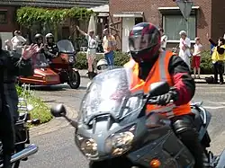 Leden van een motorclub begeleiden een zijspanrit met gehandicapten
