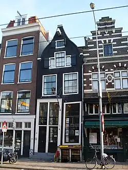 Huis met latere gevel onder uit- en ingezwenkte top met rollagen