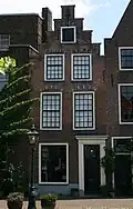 Pand met trapgevel met segmentbogen boven de vensters, gesmeed topgevelanker. Hardstenen stoep. Onderpui vernieuwd eerste helft 18e eeuw