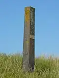 Op de dijk naar Warder een grenspaal in de vorm van een obelisk