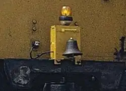 De bel en het baken voor dienst op de tramsporen, gemonteerd op de stootplaat en via een kleine stekker aangesloten op de treinsystemen zoals bij alle class 33/1 en TC-treinstellen.