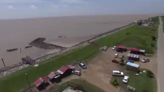 Backtrack, met op de dijk parkeerplaats en hindoetempel