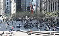 Zuccotti Park, voorjaar 2015. Het kunstwerk van Mark di Suvero is zichtbaar in de verte